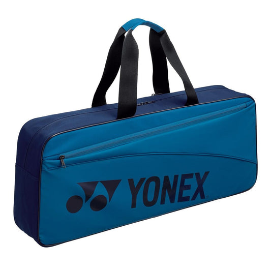 The Yonex 42331WEX Team Tournament Tennis Bag in Sky Blue, a 2023 stylish new release, features a sleek rectangular design with black handles and a large zippered front pocket. The prominent Yonex logo on the side adds an elegant flair to its modern appearance.