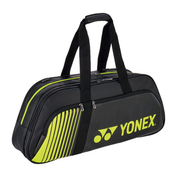 The Yonex 82431WEX Active Tournament Tennis Bag in black/lime, by Yonex, features two handles, the logo, and a striped side design. It includes multiple compartments and a shoe compartment with visible zippers for easy access.