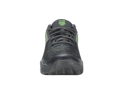 The product showcases a front view of the Sea Spray and Urban Chic athletic tennis shoe by K-Swiss, highlighted with textured detailing in Soft Neon Green. Its design emphasizes on-court performance, featuring a patterned sole ideal for clay court surfaces and laces, along with the K-Swiss logo on the tongue.