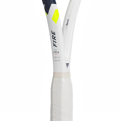 Close-up of the Tecnifibre Fire 285 Tennis Racket handle and throat, highlighting "FIRE" branding, technical specs, X-Damp vibration dampening tech, a textured grip, and geometric yellow and navy accents.