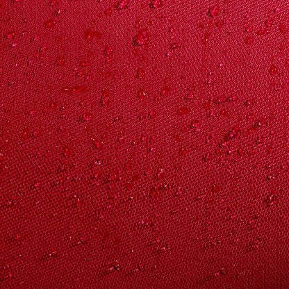 Close-up of burgundy water-resistant fabric on the Babolat Court XS 3 Racket Tennis Bag - Burgundy / Black, with scattered water droplets beading on the surface, highlighting the compact Babolat bag's waterproof texture.