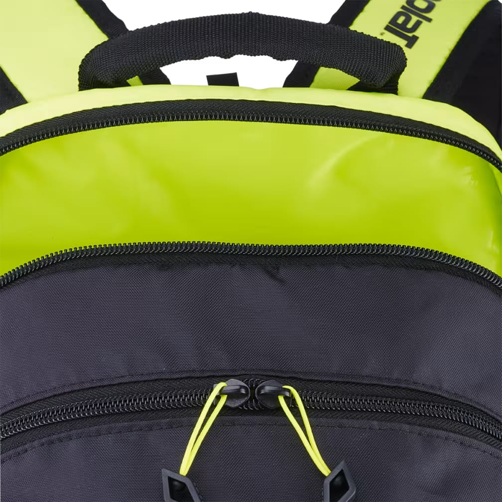 Close-up of the Babolat Kids Tennis Backpack in Metallic Grey and Fluo Yellow, featuring a black front compartment with bright yellow zipper pulls and a bold yellow top section with black straps—making it a stylish choice for young tennis players.