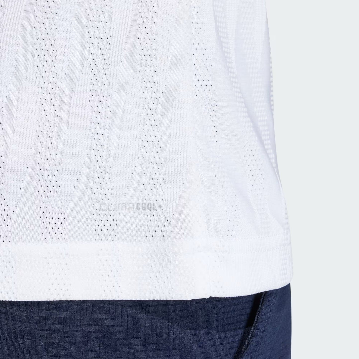 Close-up of the lower back of an adidas Climacool+ Airchill Freelift Mens Tennis T-Shirt in white, showing perforated fabric with "CLIMACOOL" text, paired with dark navy pants. Subtle striped pattern visible on the shirt.