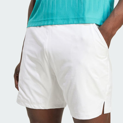 A person wearing adidas Climacool Ergo Men's Tennis Shorts in white, with hands in pockets, shown from the waist down against a plain background.
