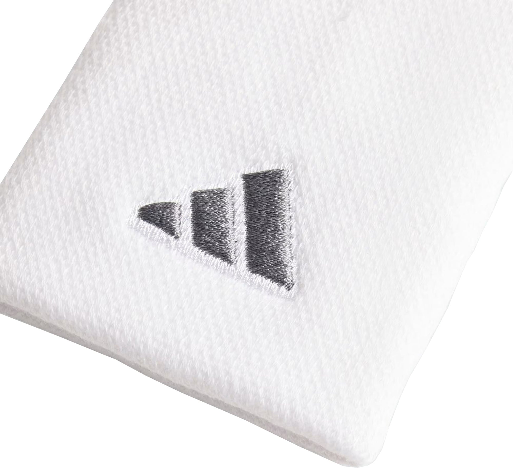 Close-up of a white textured fabric featuring adidas’ three-striped triangular logo, showcasing the adidas Large Tennis Wristband - White.