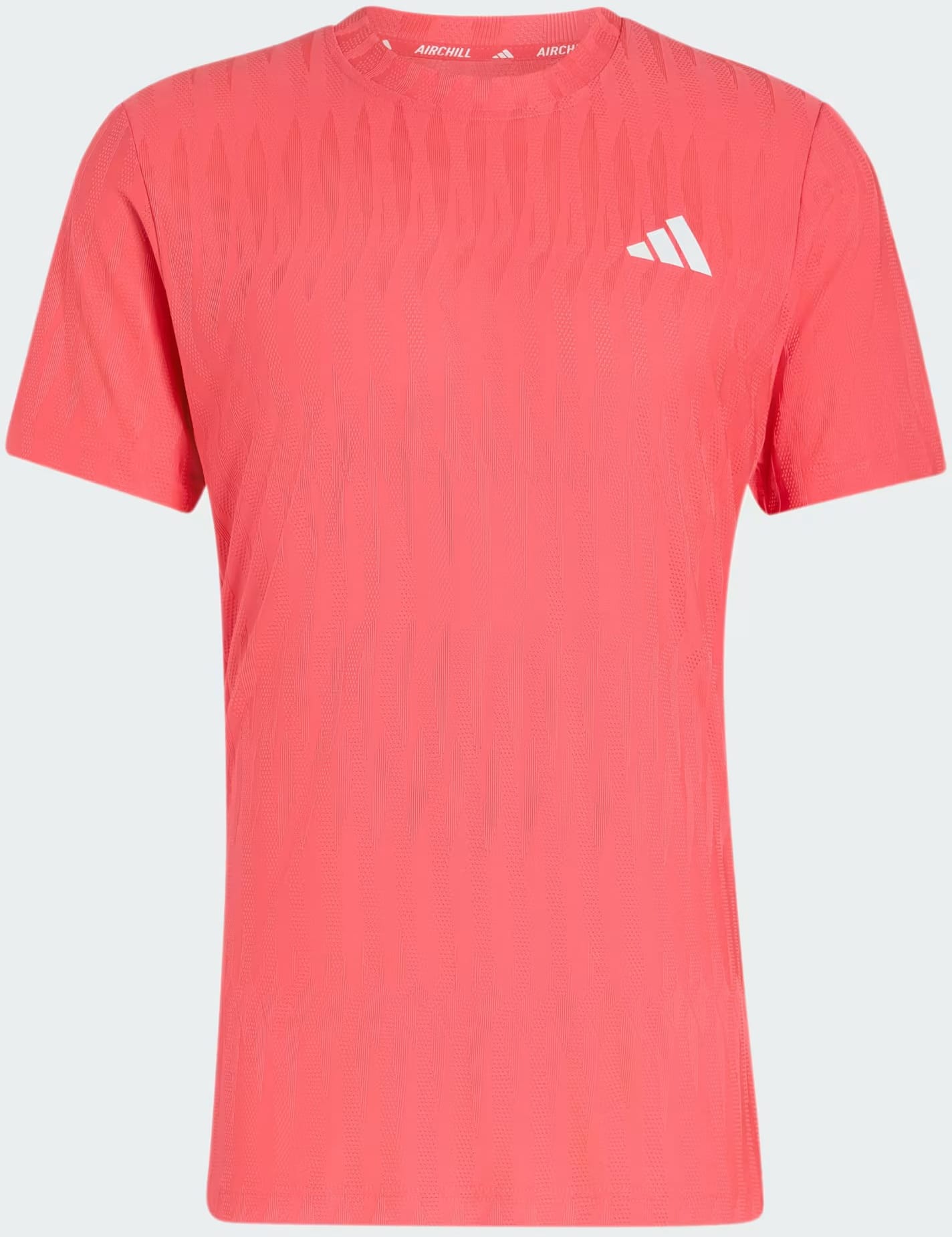 The adidas Climacool+ Airchill Freelift Men’s Tennis T-Shirt in Pure Turbo features a coral pink color with short sleeves, a subtle wavy pattern, and a small white adidas logo on the left chest. This lightweight performance tee incorporates Airchill technology to keep you cool and comfortable on the court. The shirt is shown against a plain light background.