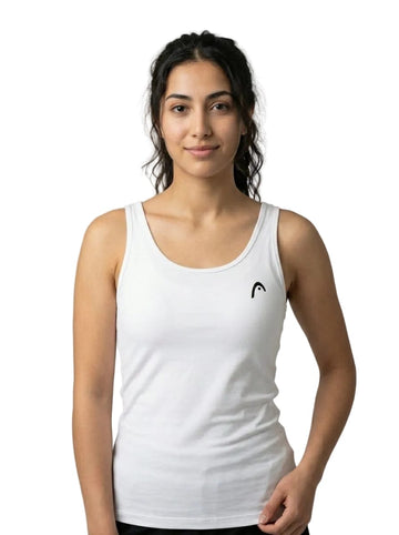 A woman stands against a plain white background, smiling softly and wearing the HEAD Spirit II Womens Tennis Tank Top - White by HEAD, which features a small logo on the left side. Designed with Moisture Transfer Microfiber and cooling technology, this tank top provides comfort and breathability for any active occasion.