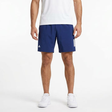 A person wearing a white t-shirt, adidas ADIDAS Men’s 3 Stripe Tennis Shorts in navy, and white sneakers stands against a plain white background. Only the body from shoulders to feet is visible.