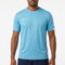 A man stands against a plain white background wearing the Babolat Play Men’s Crew Neck Tennis T-Shirt in cyan blue, which features short sleeves and is made from recycled polyester, paired with dark shorts.