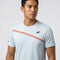 A man wearing the Babolat Play Men’s Crew Neck Tennis T-Shirt in Illusion Blue stands against a plain light background, looking slightly to the side.