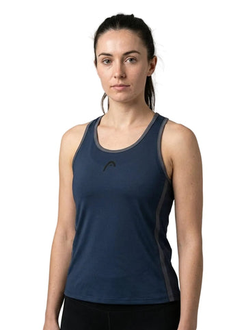 A woman with long dark hair tied back is wearing the HEAD Club 25 Tech Womens Tennis Tank Top in navy, made from breathable sportswear fabric. She stands against a plain white background, looking at the camera with a neutral expression.