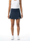 A woman wearing a white tank top and the HEAD Club Basic Women’s Tennis Skort Long in navy, featuring moisture-wicking fabric and the signature “HEAD” logo, paired with white sneakers. She stands against a plain white background with her arms relaxed at her sides.