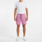 A person stands facing forward against a white background, wearing a plain white t-shirt, HEAD Performance Men’s Play Tennis Shorts in cyan pink by HEAD with a drawstring waist, and white sneakers.