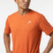A man stands with his hands on his hips against a plain white background, wearing the HEAD Slice II Mens Tennis T-Shirt in orange. This short-sleeve t-shirt by HEAD features a small white logo on the chest and is designed with moisture-wicking fabric to keep you comfortable both on and off the court.