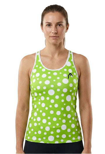 A woman stands facing forward against a white background, wearing the HEAD Spirit II Womens Tennis Tank Top - IGXR by HEAD in green with white polka dots. This tank top is designed with advanced cooling technology and moisture transfer microfiber to keep you comfortable both on and off the court.