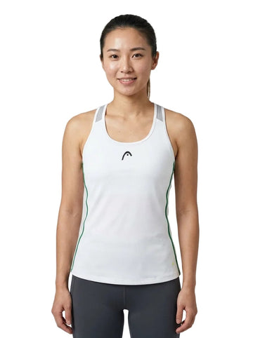 A woman with long dark hair styled in a ponytail wears the HEAD Spirit Women’s Tennis Tank Top in white by HEAD, featuring green accents and crafted with advanced Moisture Transfer Microfibre technology. She pairs it with dark leggings and stands smiling at the camera against a white background.
