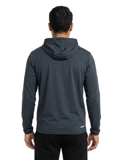 A person is standing with their back to the camera, wearing a dark gray HEAD Topspin Mens Tennis Hoodie - NVXU and black pants—an ideal piece of sportswear by HEAD, featuring a comfortable fit and moisture-wicking hoodie design.