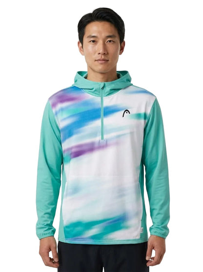 A man stands facing forward in the HEAD Topspin Mens Tennis Hoodie - TQXU by HEAD, showcased in teal and white with striking purple and blue streaks. This sportswear hoodie features a half-zip front, a small HEAD logo on the left chest, and blends modern style with moisture-wicking comfort for active individuals.