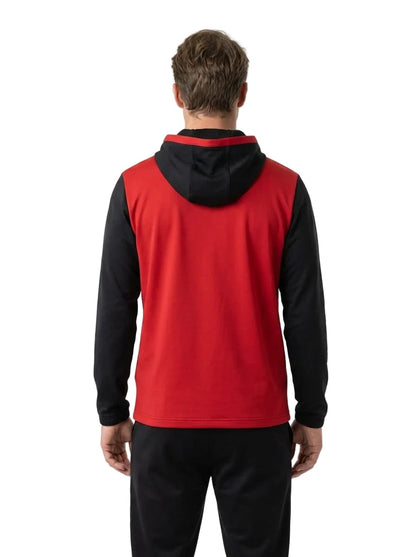 A man with short brown hair stands facing away, dressed in black pants and wearing the HEAD Vision Topspin Men’s Tennis Hoodie - BKXV by HEAD. This hoodie features a bold black design with contrasting sleeves and hood, made from moisture transfer microfibre for excellent comfort. The background is plain white.
