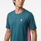 A man wearing the K-Swiss Hypercourt Mix Melange Men’s Tennis T-Shirt in Stargazer/Pink, featuring a small pink emblem on the chest and pink side panels, stands against a white background.