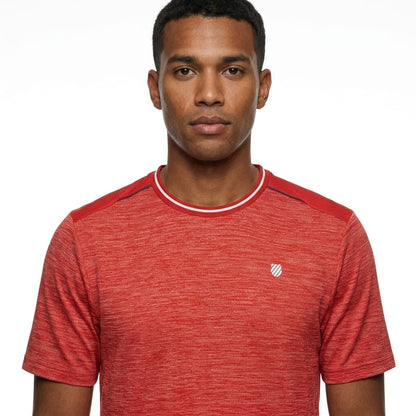 A man stands against a plain white background, looking directly at the camera with a neutral expression, wearing the K-Swiss Tac Hypercourt Tennis T-Shirt in Lollipop Melange—a comfortable, short-sleeve sportswear top featuring a small white K-Swiss logo.
