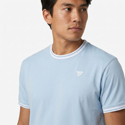 A person wearing a Tecnifibre Team Stretch Men’s Tennis T-Shirt in Glacier Blue looks to the side against a plain white background.