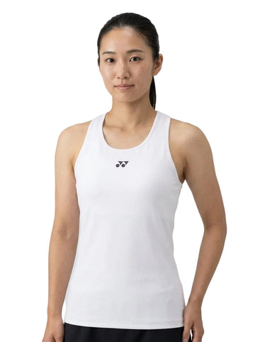 A woman with long dark hair tied back, wearing the Yonex 20760 Womens Tennis Tank Top in white—a sleeveless design featuring a small black Yonex logo at the center—stands facing forward against a plain white background. This high-performance sportswear is engineered for comfort and style, offering moisture-wicking capabilities ideal for active athletes during tournaments.