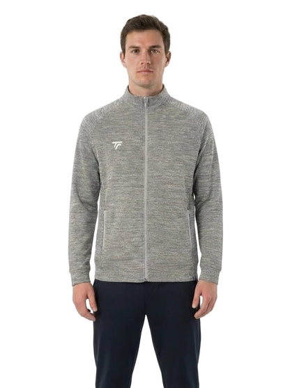 A man wearing a Tecnifibre Men’s Team Tennis Jacket in Silver, featuring a lightweight, breathable design with a small white Tecnifibre logo on the left chest, paired with dark pants and standing against a plain white background.