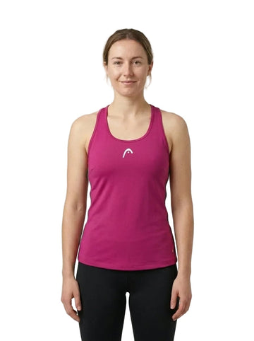 A woman stands facing forward, smiling slightly, wearing the HEAD Spirit Womens Tennis Tank Top in vivid pink and black leggings against a plain white background. This HEAD sports tank top features Moisture Transfer Microfibre to keep her cool and comfortable during workouts.