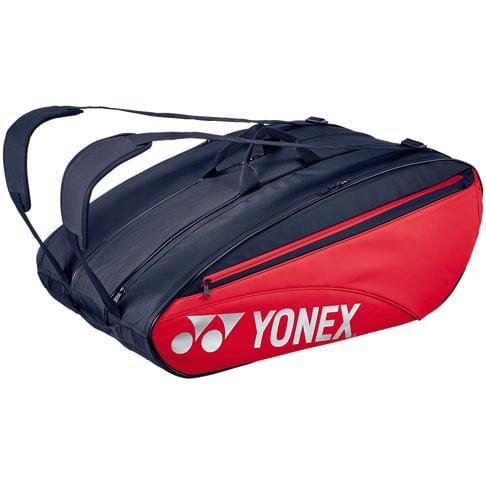 The Yonex 423212EX 12 Piece Racket Bag in Scarlet, featuring a red and black design with shoulder straps and branded logo, offers large zippered compartments that can accommodate up to 12 rackets along with additional sports equipment.