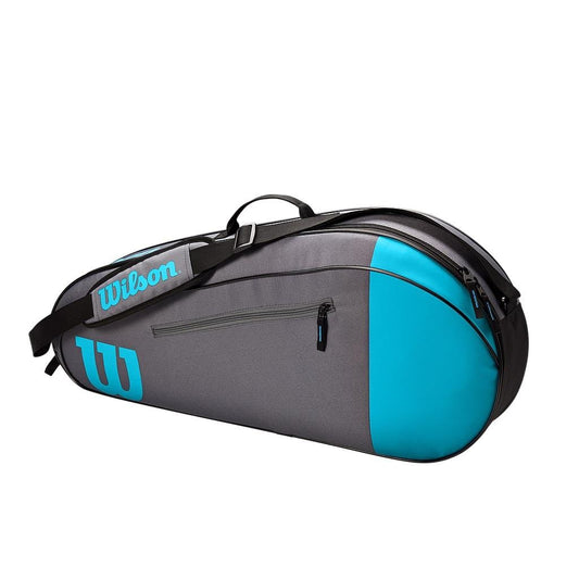 A blue and gray tennis racket bag from the Wilson Team Collection, featuring a sleek design with black straps. It includes a side zipper pocket for convenient access on the go.