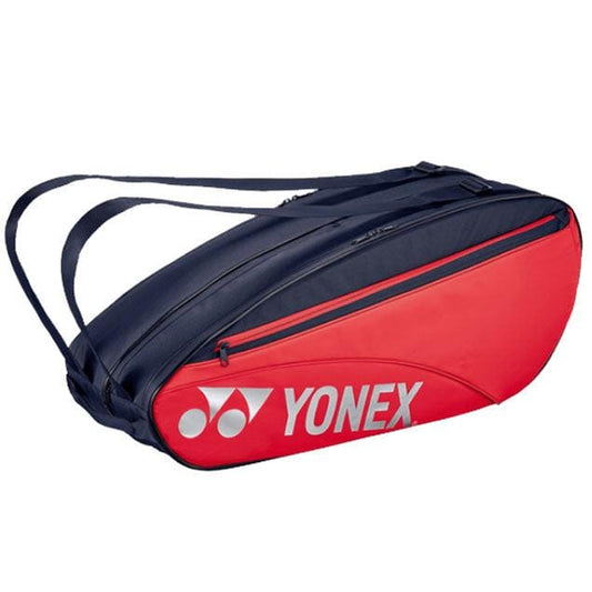 The Yonex 42326EX 6 Piece Racket Bag - Scarlet features a vibrant red and black color scheme and includes adjustable shoulder straps along with multiple compartments, such as a wet compartment for gear. It's ideal for transporting rackets and sports equipment, showcasing the Yonex logo prominently on the side.