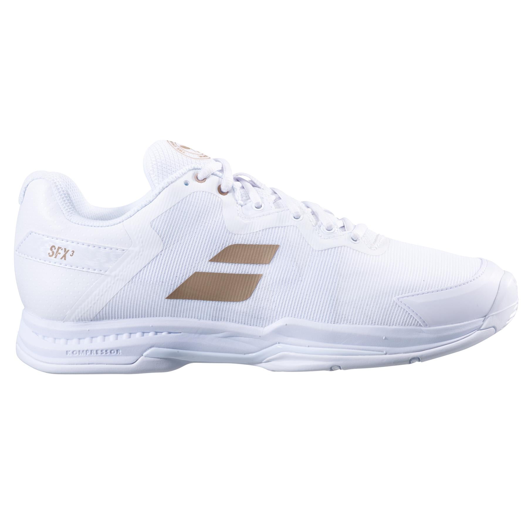 A sleek athletic shoe with a white design enhanced by gold accents and the Babolat brand name on the side. It features a Kompressor System for improved cushioning, a textured sole, and white laces—a perfect mix of style and performance, making it ideal for any sports enthusiast.