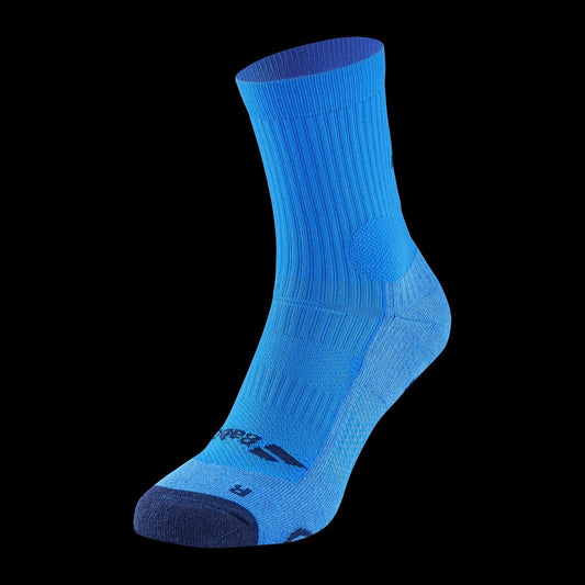 Displayed against a black background is the Babolat Pro 360 Men's Sock in Drive Blue, featuring a deep blue toe and heel. Engineered with varying textures and ribbed sections, this sock includes underfoot cushioning for enhanced performance and comfort. The Fiberdry technology ensures optimal breathability.