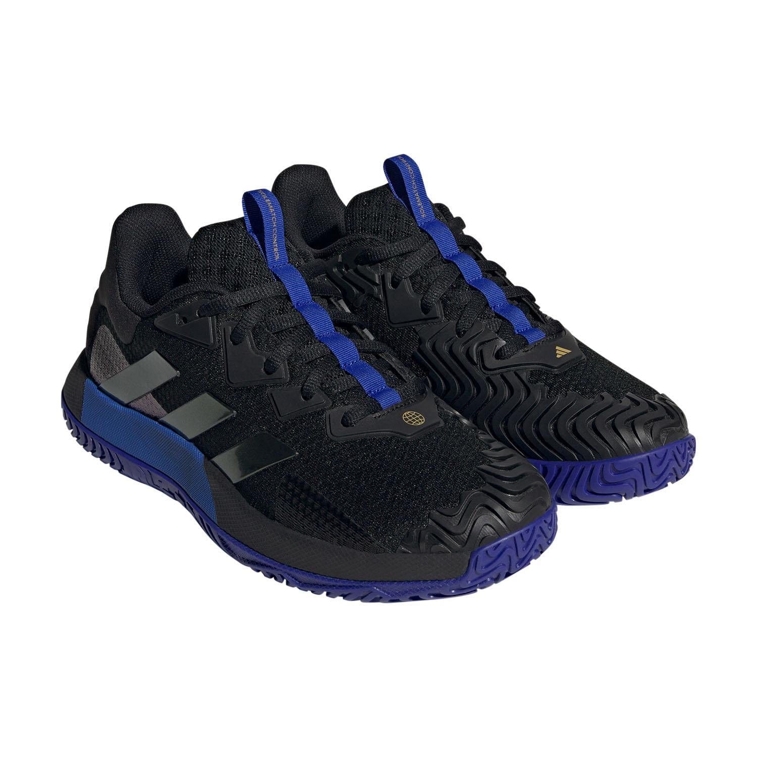 Sleek and stylish, the adidas SoleMatch Control Men's Tennis Shoes in Black and Blue showcase a textured wave-like pattern with blue accents on the tongue and soles. These athletic shoes offer bounce cushioning and abrasion resistance for enhanced durability. Positioned side by side at a slight angle, their lace-up closure is prominently displayed.