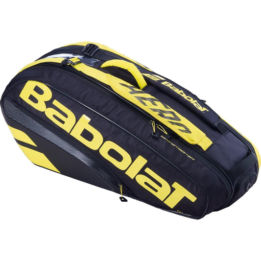 The Babolat RH6 Pure Aero 6 Racket Tennis Bag in black and yellow is displayed, featuring several compartments, one of which is insulated. The vibrant yellow Babolat logo prominently decorates the sides. This bag includes zippers and a convenient shoulder strap for easy carrying.