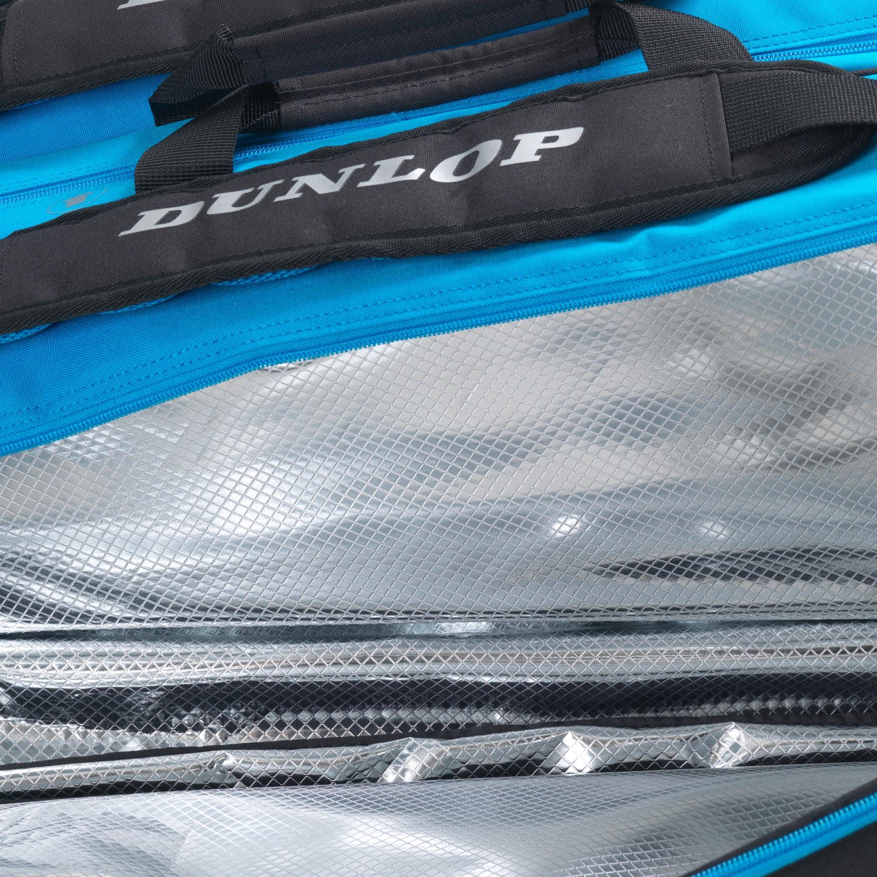 Close-up image of an open Dunlop FX Performance 12 Racket Thermo Tennis Bag - Black / Blue, showcasing its blue exterior and silver, reflective, insulated interior. The bag is partially unzipped to reveal the textured lining and specialized racket compartments that maintain a stable temperature for its contents.
