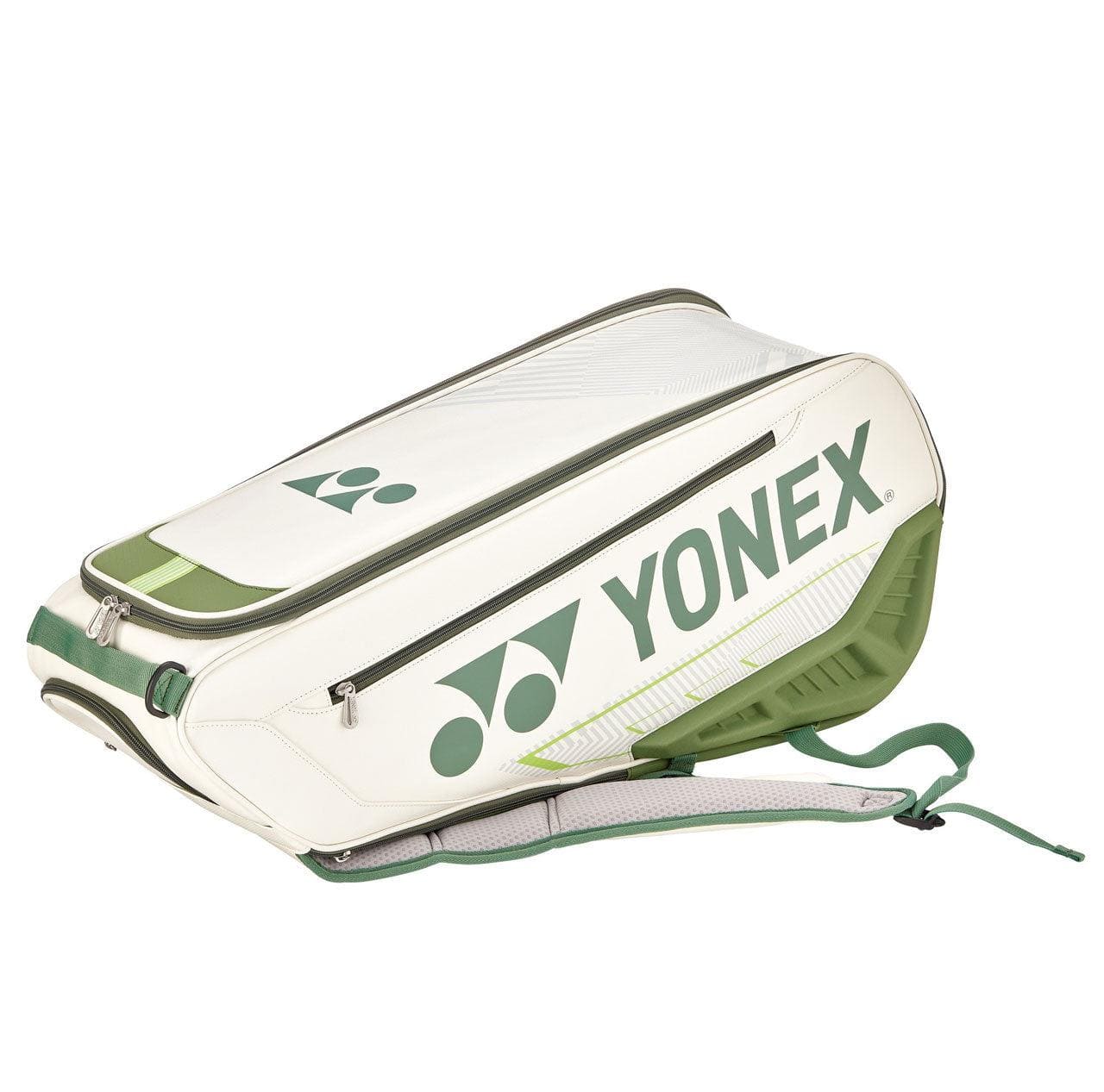Introducing the Yonex 02326EX Expert 6 Piece Racket Bag in White/Moss Green, adorned with zippers and shoulder straps for easy carrying, and prominently displaying the Yonex logo on the side. For added convenience, it includes a detachable laundry pouch. The bag is showcased at a slight angle against a plain white background.