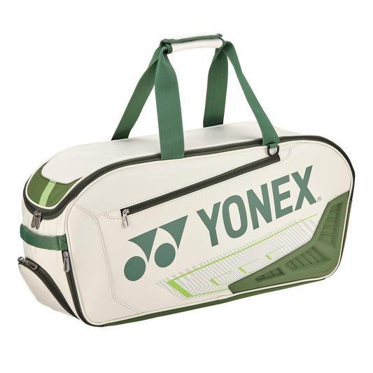 The Yonex 02331WEX Expert Tournament Bag, featuring a sleek white and moss green design, comes with green handles and prominently displays the Yonex logo on the side. Perfect for tournaments, this bag combines style with functionality, ensuring you carry your gear with confidence.