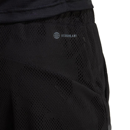 Close-up of the adidas Melbourne 2in1 Men's 7 Inch Tennis Shorts showcasing the "AEROREADY" logo. The black mesh fabric offers a textured, breathable design with an elastic waistband, making it perfect for athletic activities and incorporating sustainable carbon recycling materials.