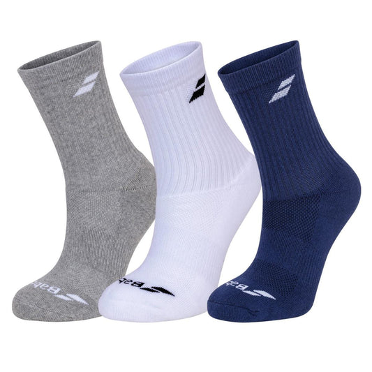 Displayed side by side are three pairs from the Babolat Long Tennis Socks 3 Pack in white, blue, and grey. Each sock showcases a logo near the top and toe area. Crafted with reinforced comfort and ventilated zones, the ribbed fabric ensures softness and breathability.
