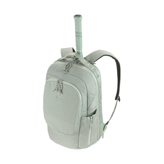 The HEAD Pro 30L Tennis Backpack - LNLL, made from sustainable materials, boasts a light green design with several zippered compartments. It is equipped with adjustable shoulder straps and a handle. The bag also features a dedicated slot that perfectly accommodates a matching green-grip tennis racket.