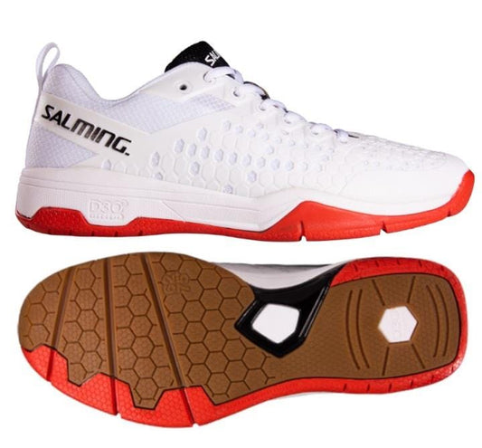 The Salming Eagle Women's Indoor Court Tennis Shoes in white and red feature a hexagonal pattern on the brown sole for extra durability. The upper design includes textured perforations aimed at reducing shock. One of the shoes is positioned on its side, prominently displaying the "SALMING" logo, while the other highlights the grip pattern on the sole.